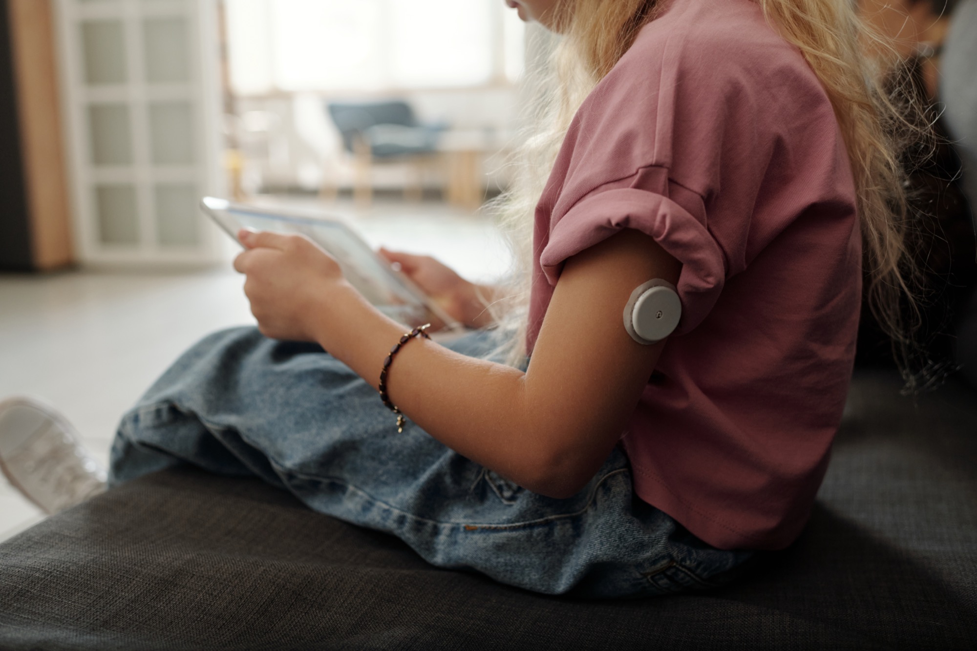 Two people working side by side at keyboards and laptops in an office