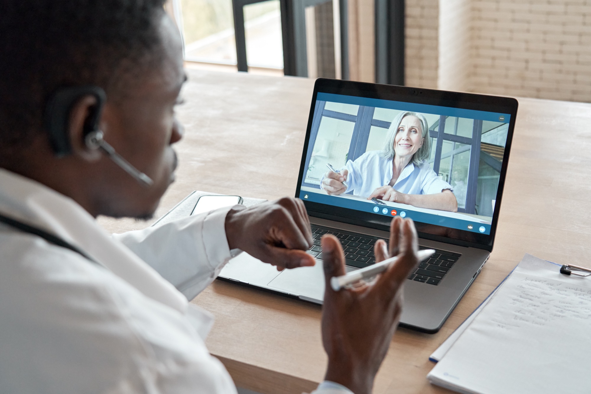 Doctor conducting a telehealth video consultation with a patient on a laptop