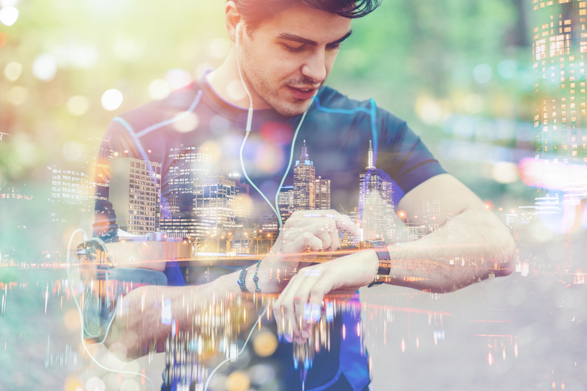 Double-exposure image of a runner checking a fitness wristwatch overlaid with a city skyline, representing connected health data