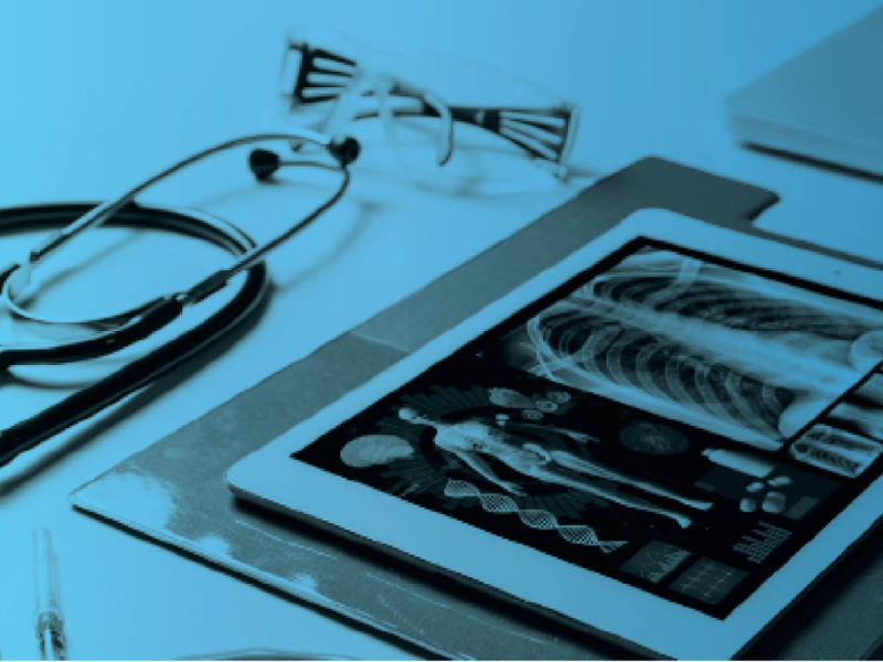 Stethoscope and tablet displaying a medical X-ray on a desk, with a blue tint overlay.