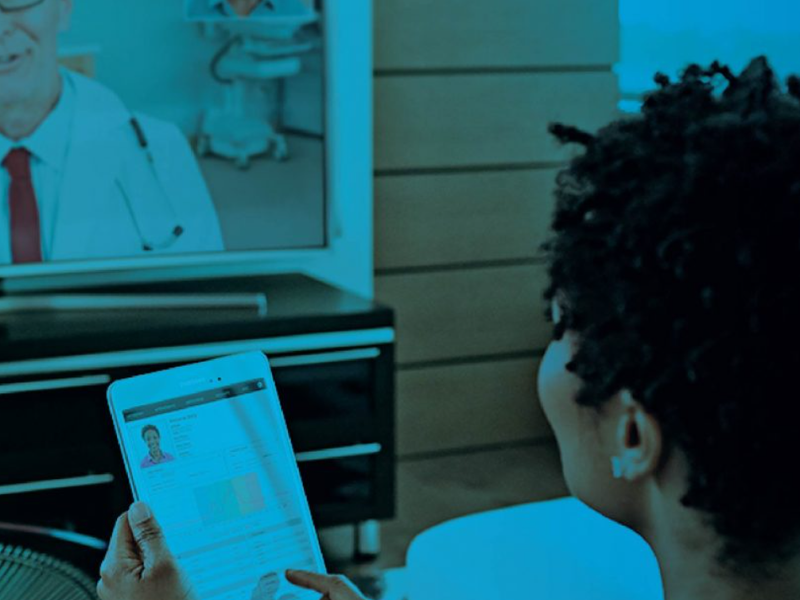 Woman having a telehealth video consultation with a doctor on a tablet at home, with a teal overlay.