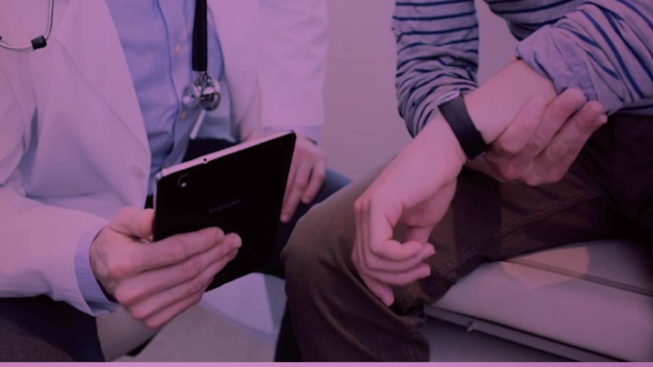 Doctor reviewing health data on a tablet with a patient wearing a fitness tracker, with a pink overlay.