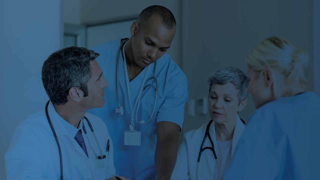 Group of healthcare professionals in scrubs having a discussion, with a blue overlay.
